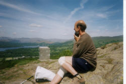 picture of a walker listening to a commentary on the view from the top of a fell using a recorded tape